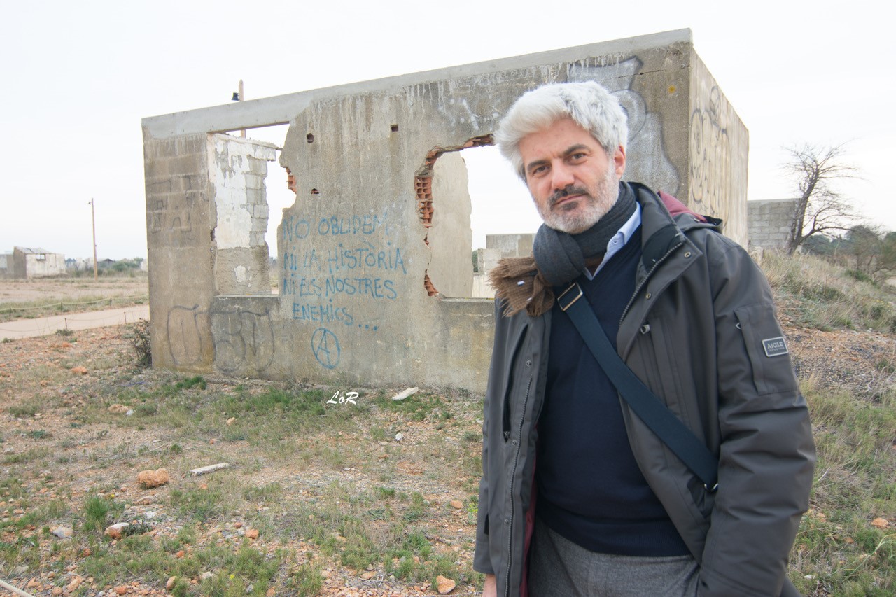 Prix Goncourt, Prix Goncourt des lycéens, Prix des libraires, Prix Jean-Giono… En l’espace de quelques romans, Laurent Gaudé était de passage en Roussillon à l’invitation du CML, du Mémorial et de SOS Méditerranée. 300 personnes sont venues à sa rencontre. Mais Laurent Gaudé est un homme de conviction. Parrain de SOS Méditerranée, une association européenne de sauvetage en mer Méditerranée créée en juin 2015, il œuvre depuis des années aux côtés de structures d’aide aux migrants. 300 personnes sont venues à sa rencontre au Mémorial de Rivesaltes, dont plusieurs classes de lycéens. Quand il est arrivé jeudi 25 mai à Perpignan par l’avion de midi, il a découvert, en plongeant sur l’aéroport, un curieux paysage dans la plaine. Un mouchetis de traits blancs rassemblés en carrés et, au milieu, un immense rectangle couleur sable, comme une table de géant. A quelques kilomètres des pistes, dans un paysage de vignes et de zones d’activités surplombées d’éoliennes, il est arrivé au mémorial du camp de Rivesaltes, ce point névralgique de la mémoire de l’internement en France. Une multitude de baraquements en ruines, parfaitement alignés. C’est ce que l’on aperçoit depuis le ciel. De ces bâtiments précaires, couverts de tags, sans toit pour la plupart, au bord de l’effondrement, suintent tristesse et mélancolie. On dirait une œuvre d’Anselm Kiefer, l’artiste allemand dont les sculptures, travaillées par le temps, s’effondrent dans un fracas de verre brisé. Il n’est pas ici par hasard. On connait tous son engagement. Il écrit sur le monde qui saigne. Il plaide pour une Europe ouverte aux réfugiés. Partir, c’est mourir un peu. Pour beaucoup de migrants, partir, c’est mourir complètement. On estime à plusieurs dizaines de milliers le nombre de réfugiés qui ont péri en Méditerranée depuis quinze ans. A ces exilés en péril, mais aussi aux victimes de l’ouragan Katrina, aux rescapés du tremblement de terre en Haïti qu’il évoque dans un roman de vie et de mort, Danser les ombres, il a donné un visage et une âme dans ses romans. Mais il serait injuste de réduire Danser les ombres à un roman sur la catastrophe. Il dresse avant tout le portrait d’une ville incroyable et de ses habitants qui, toujours, se relèvent. Plus que ça, il apporte à ces sujets sa lumière particulière. Il insuffle de la douceur dans l’horreur, de l’épique dans le dramatique. Eldorado témoigne aussi de cette qualité de métissage. Il y raconte une double migration. Celle de Soleiman et Boubakar, du Soudan à Ceuta, et celle, moins classique, du commandant Piracci, garde-côte sicilien qui laisse le confort de l’Europe pour errer comme une ombre sur les routes d’Algérie. « Eldorado » provoque des sueurs froides, car, dans ce magnifique roman, le commandant Piracci constate un tel appétit dans le regard des réfugiés qu’il décide de prendre la route lui aussi. Comme si l’exil était un choix et non une fatalité…