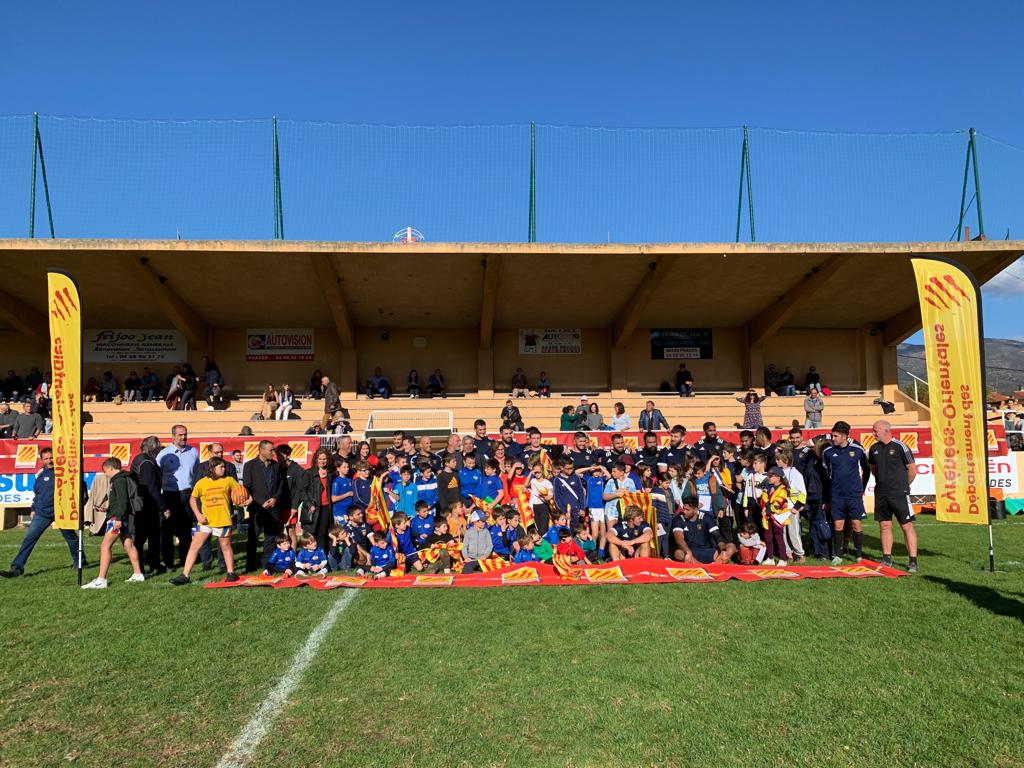 Photo de famille sur le terrain avec les jeunes de Prades, les joueurs de l'USAP, le staff et les élus.