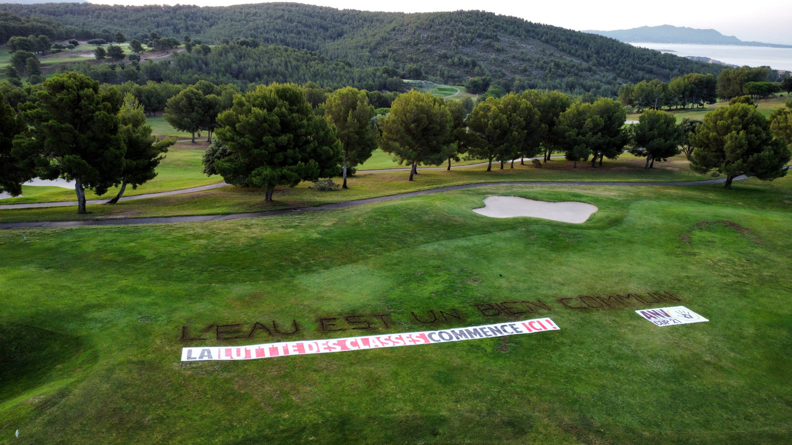 Contre l'accaparement de l'eau, ANV-COP21 trace un message géant à la pioche dans un golf