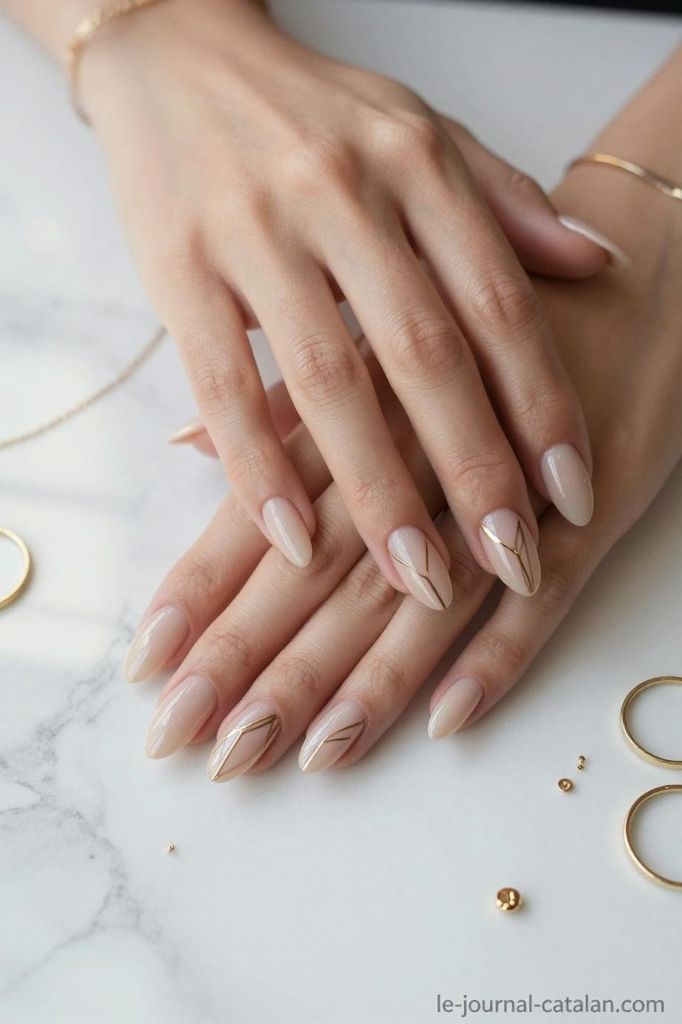 Almond Nails With Design displaying white geometric patterns with rose gold accents