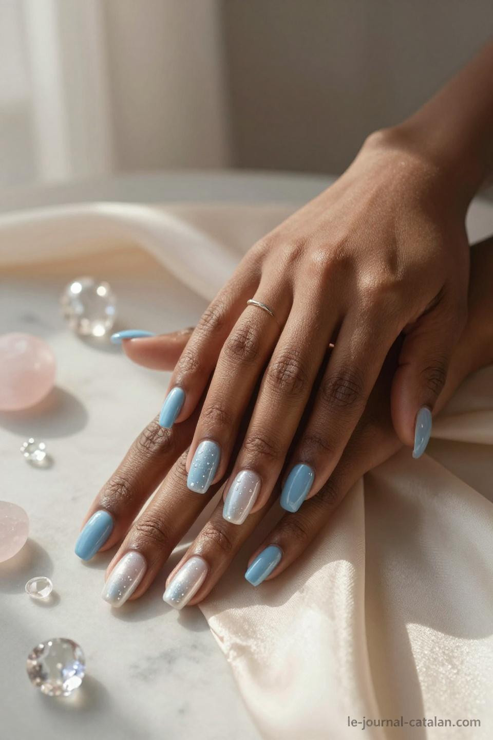 Dark blue nails featuring baby blue to white ombre gradient on almond shaped nails