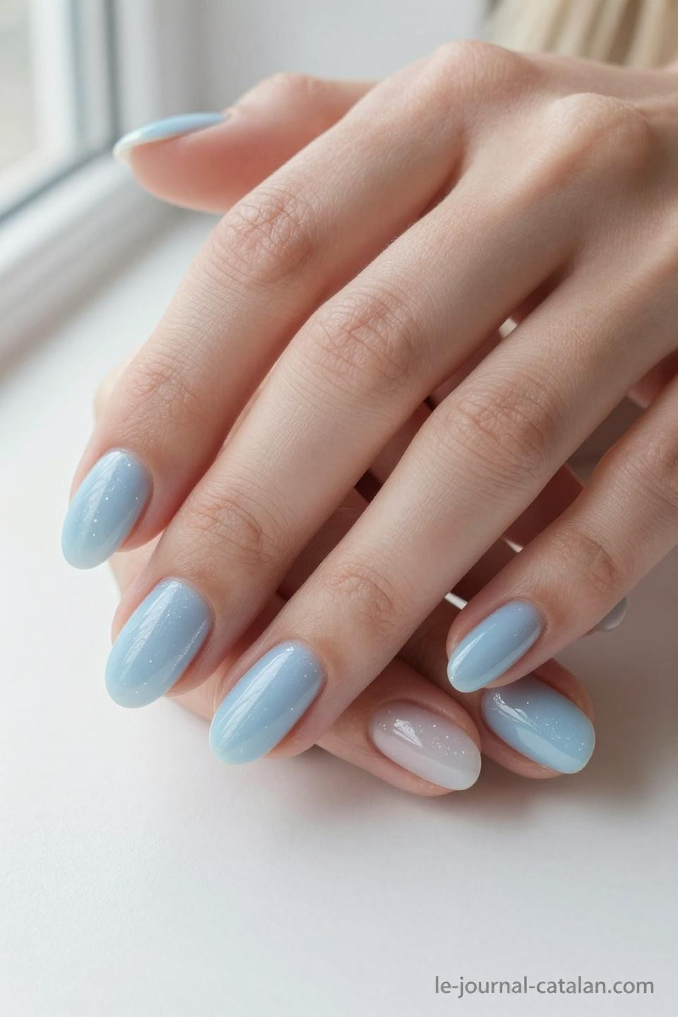 Light blue nails with design featuring baby blue gel with pearl shimmer on almond nails