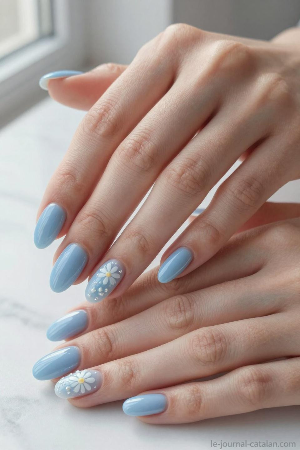 Blue nail inspo featuring baby blue with hand painted white daisy nail art