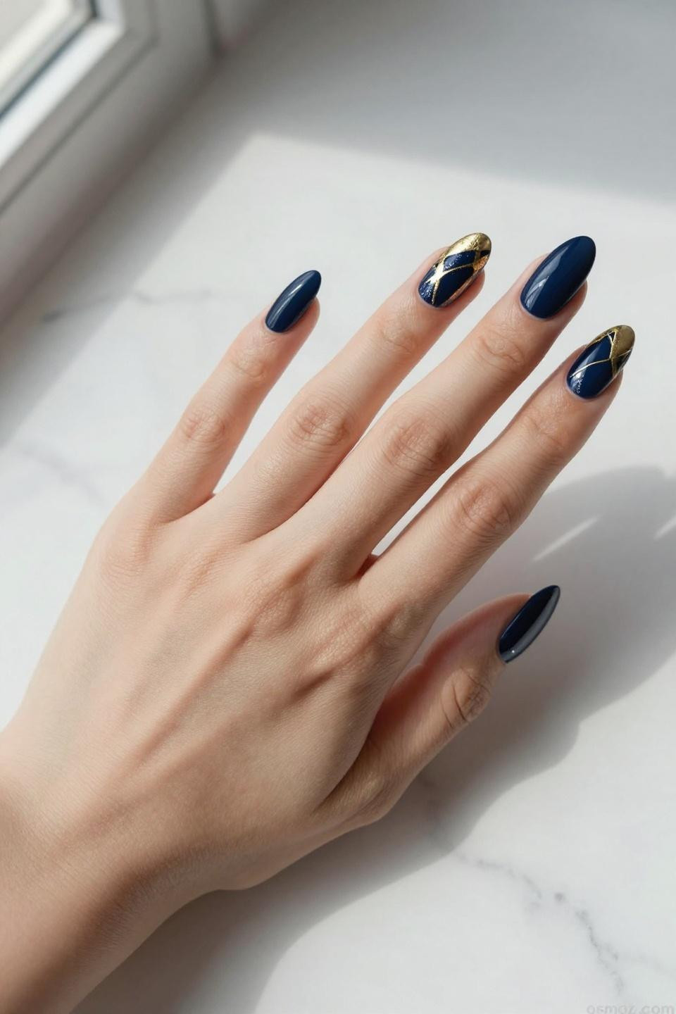 Blue Nails Ideas featuring navy gel with geometric gold foil on marble surface