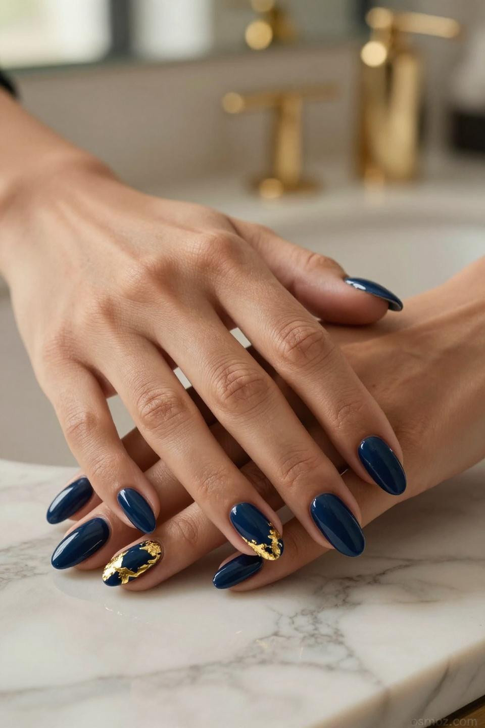 Blue Nails Ideas with navy gel and gold geometric patterns on marble surface