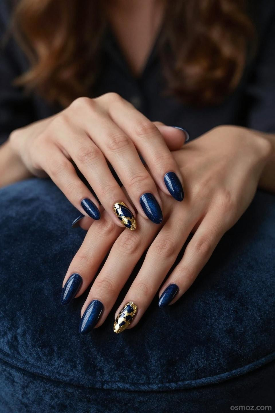 Blue Nails Ideas with navy gel and gold foil on almond nails in luxury lounge setting